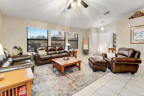 A spacious living room with a brown leather sofa set, a wooden coffee table, and a patterned rug. - Stunning home with mountain views, pool, fast WiFi, central AC & W/D (Mesa)