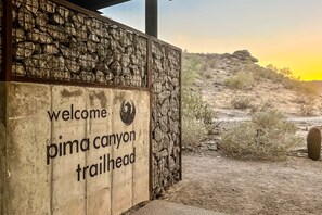A wooden sign with the text "Welcome to Pima Canyon Trailhead" and a decorative metal gate. - South Mountain home with pool, grill, fireplace & fast WiFi - snowbird-friendly (Phoenix)
