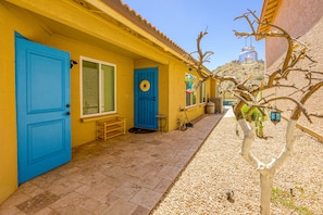 A yellow building with blue doors and windows, a small porch, and a tree with hanging lanterns. - South Mountain home with pool, grill, fireplace & fast WiFi - snowbird-friendly (Phoenix)
