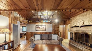 Ein gemütliches Wohnzimmer mit Holzboden, Kamin, Sofa und Couchtisch.