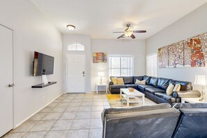 A living room with a sofa, coffee table, and TV. - Stunning home  with private heated pool, spa, firepit, grill & alfresco dining (Cathedral City)