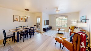 Un amplio espacio habitable con una mesa de comedor, sillas, un sofá y un televisor.