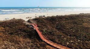Una strada costiera che porta a una spiaggia con un ponte rosso.
