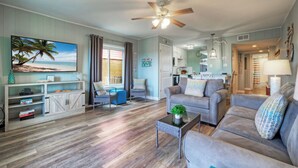 A living room with a sofa, armchairs, a coffee table, and a TV. - Rest Ashored by Avantstay Port A Condo + Beach Access + Pickleball Court + Basketball Court (Port Aransas)