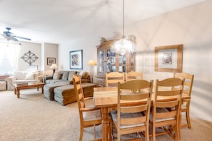 A living room with a dining table, chairs, a sofa, a coffee table, and a chandelier. - Comfortable Condo w/ Fast WiFi & Central A/C plus a Shared Pool & Hot Tub (Scottsdale)