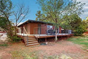A rustic cabin with a wooden exterior, a covered deck, and a staircase leading to the entrance. - Red Rock views & relaxation await at this charming Sedona escape (Sedona)