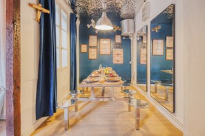 A dining area with a long table set for a meal, framed artwork on the walls, and a ceiling with hanging decorations. - Planet 612 - Capitol view (Toulouse)