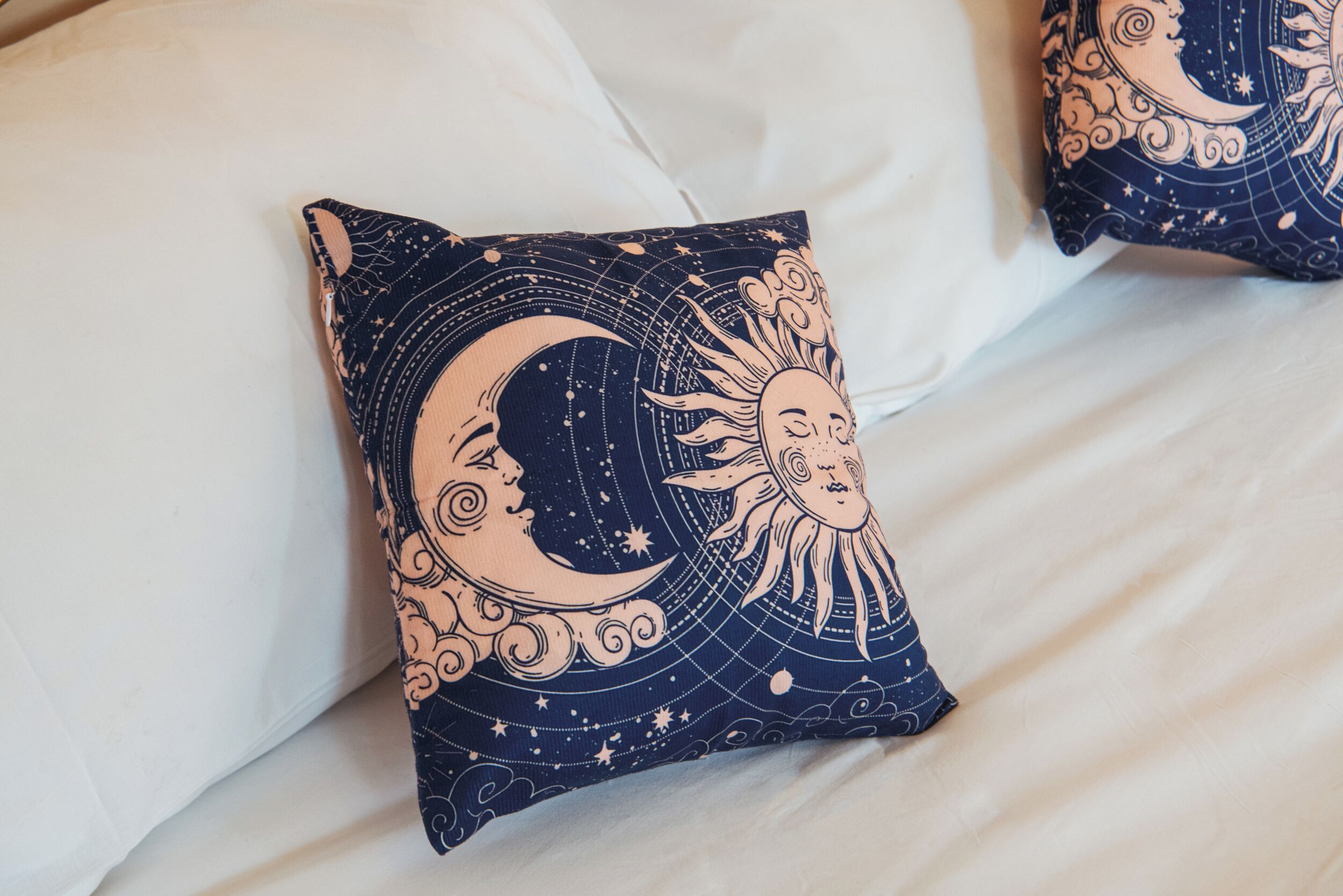 Un coussin orné d’un motif céleste représentant la lune et le soleil.