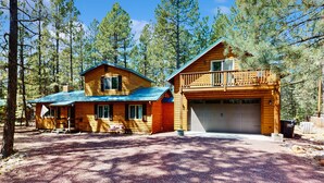 Une cabane en bois avec un garage, une véranda et une allée.