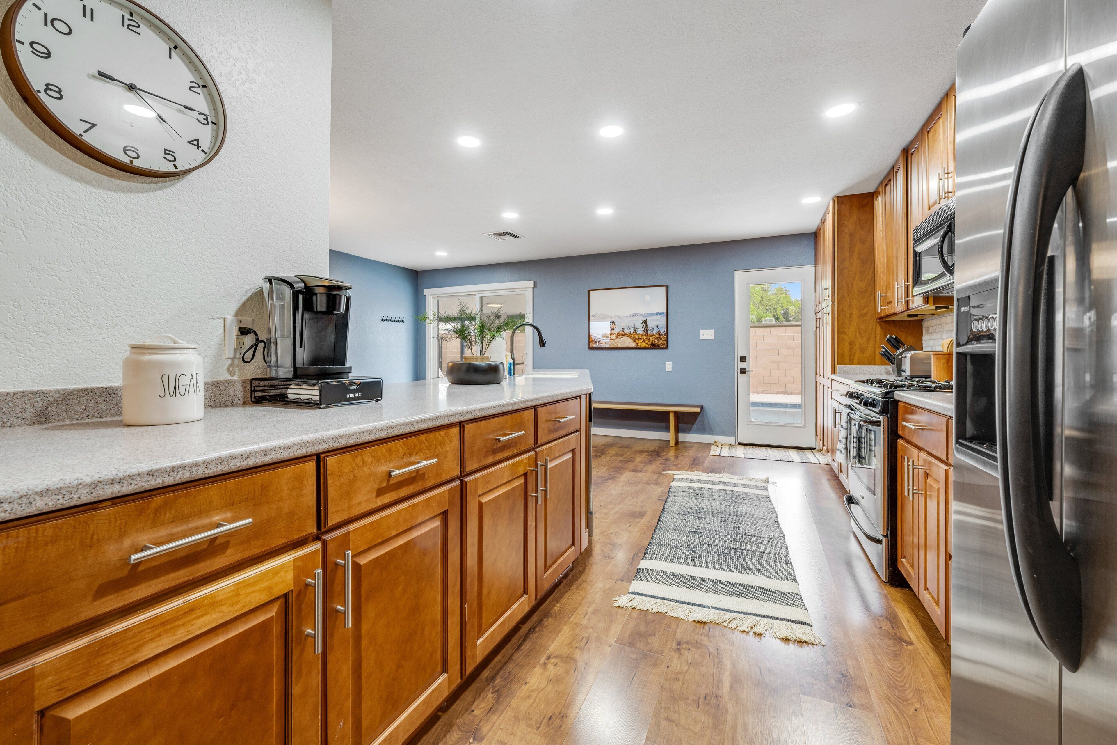 A modern kitchen with wooden cabinets, stainless steel appliances, and a coffee maker on the counter.