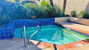 Ein Swimmingpool mit blau gefliestem Rand, einer Metallleiter und einem Schild mit der Aufschrift 'Nicht tauchen'.
