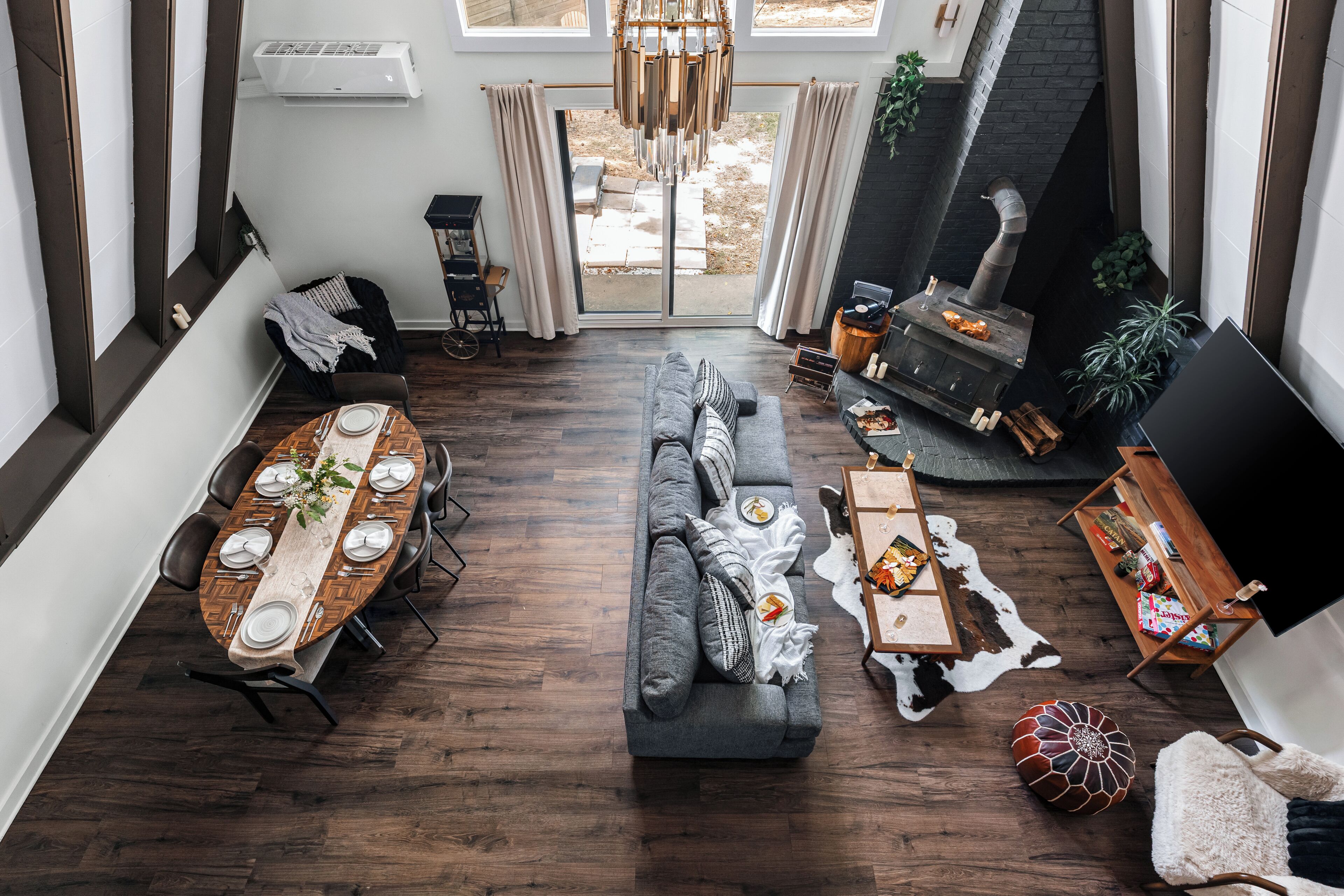 A modern living room with a dining area, a fireplace, and a large TV.