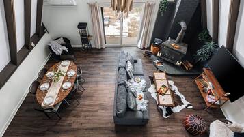 A modern living room with a dining area, a fireplace, and a large TV.