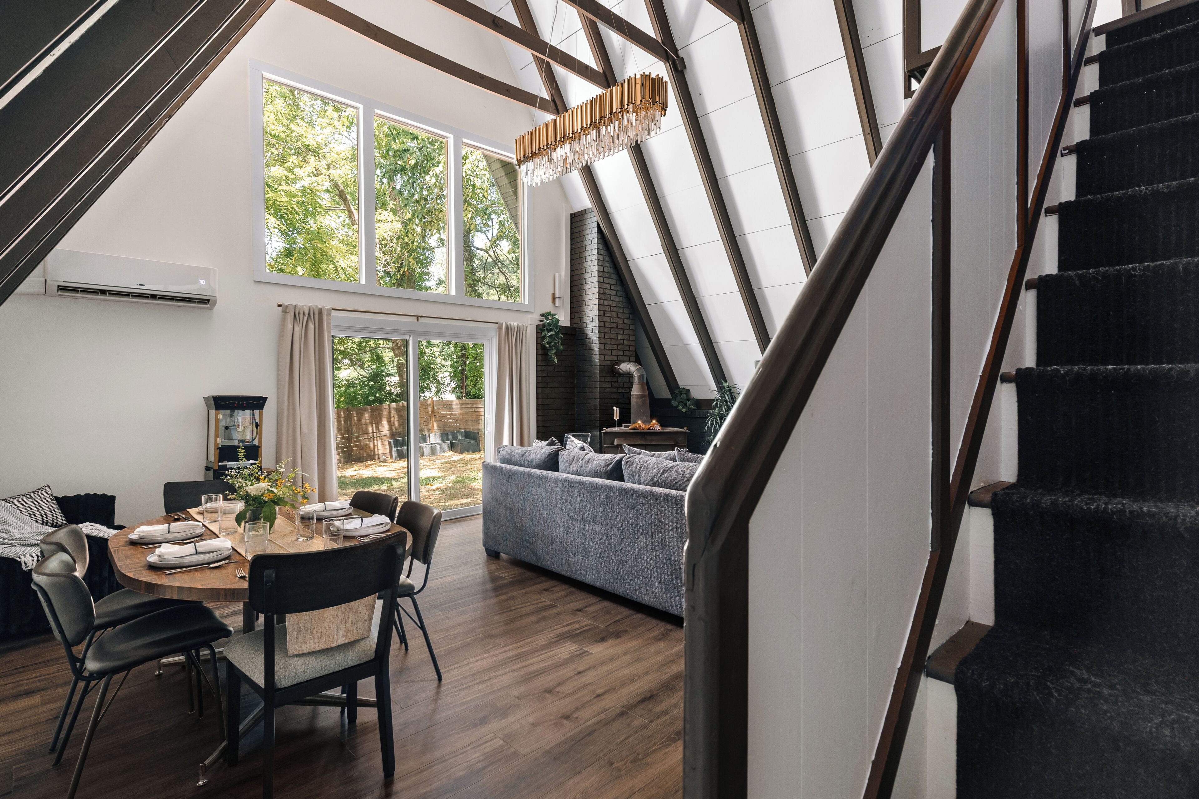 A modern interior with a dining area, a living room, and a staircase.