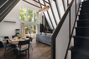 Un interior moderno con comedor, sala de estar y una escalera.