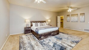 A bedroom with a large bed, two nightstands, a ceiling fan, and a rug. - Your Perfect Family Escape in Sunny Peoria – Private Pool and Relaxation Awaits (Peoria)