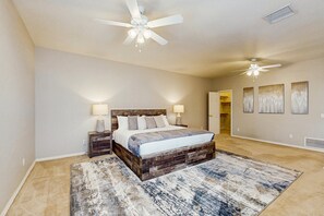 A bedroom with a large bed, two nightstands, a ceiling fan, and a rug. - Your Perfect Family Escape in Sunny Peoria – Private Pool and Relaxation Awaits (Peoria)