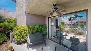 A patio with a ceiling fan, a bench, and a table. - Dog friendly condo w/two patios & shared pool/tennis - walk downtown (Palm Springs)