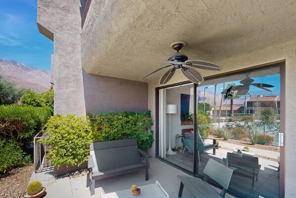 A patio with a ceiling fan, a bench, and a table. - Dog friendly condo w/two patios & shared pool/tennis - walk downtown (Palm Springs)