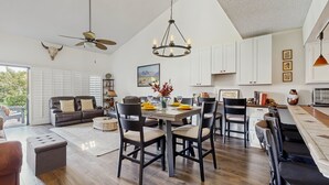 A spacious living area with a dining table, chairs, and a ceiling fan. - Dog-Friendly Updated Condo Next to Golf Courses w/WiFi, AC, W/D, Shared Pool (Palm Desert)