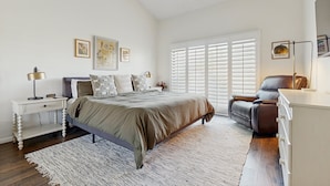 A bedroom with a large bed, a nightstand, a dresser, a chair, and a window with blinds. - Dog-Friendly Updated Condo Next to Golf Courses w/WiFi, AC, W/D, Shared Pool (Palm Desert)
