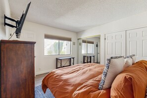 A bedroom with a bed, a dresser, a mirror, and a window. - Dog-Friendly Updated Condo Next to Golf Courses w/WiFi, AC, W/D, Shared Pool (Palm Desert)