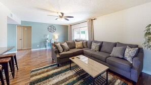 A living room with a sectional sofa, a coffee table, and a ceiling fan. - Welcoming home with private outdoor pool, pool table, patio, grill & central AC (Phoenix)