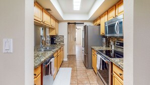 A kitchen with wooden cabinets, granite countertops, stainless steel appliances, and a skylight. - Welcoming home with private outdoor pool, pool table, patio, grill & central AC (Phoenix)