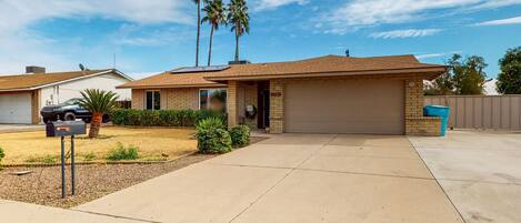 A single-story house with a garage, a driveway, and a mailbox.