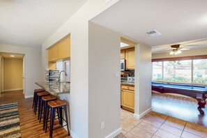 Une cuisine moderne avec un coin bar, des meubles en bois et une vue par la fenêtre.