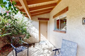Eine Terrasse im Freien mit Holzboden, einer Tür und einem Fenster mit dekorativem Schmuck.