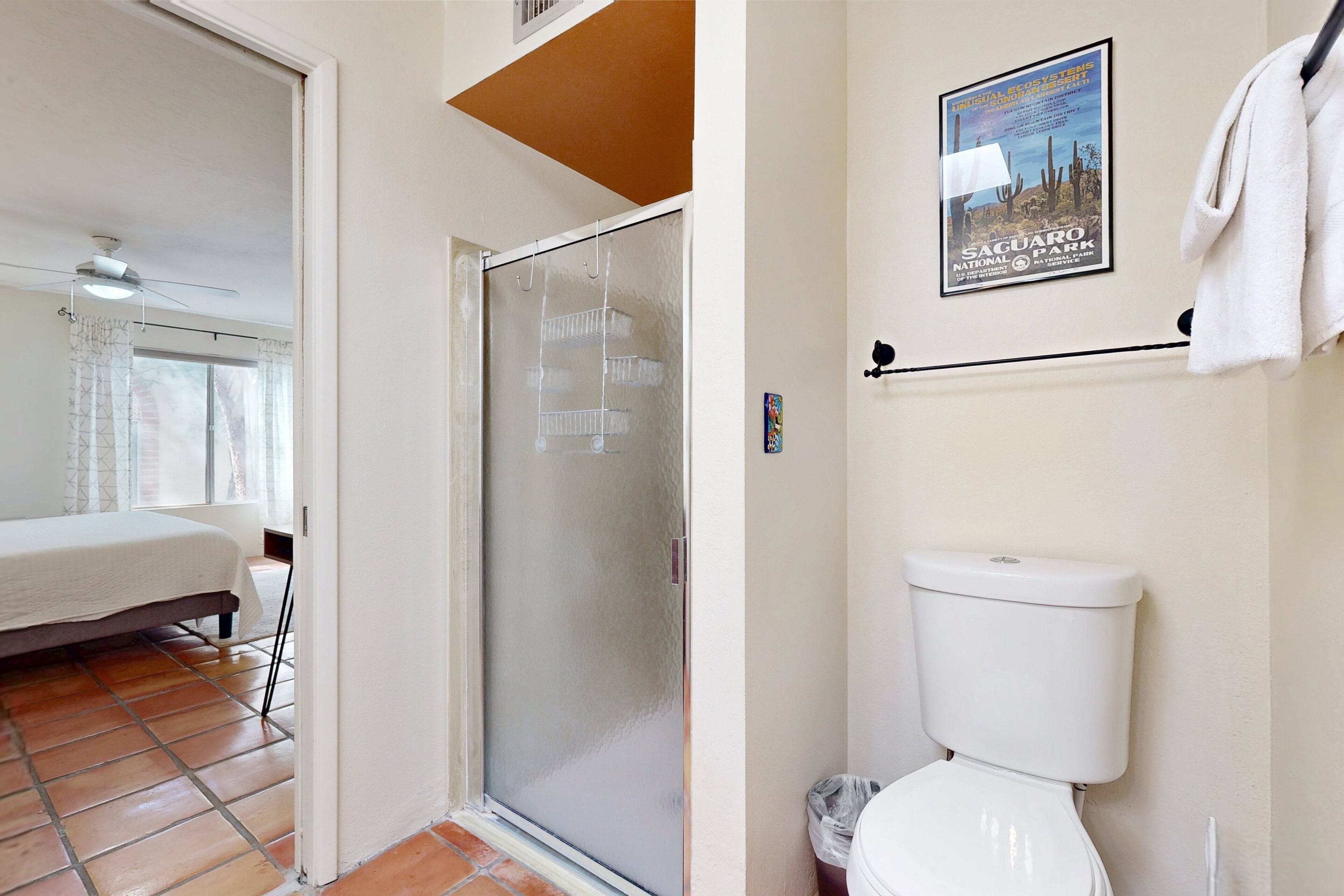 A bedroom with a bed, a sliding glass door, and a ceiling fan.