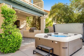 A hot tub with a step, surrounded by greenery, under a covered patio area. - Tropical retreat with pool, grill, central air-conditioning, & washer/dryer (Phoenix)