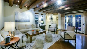 A living room with a sofa, ottomans, a coffee table, and a lamp. - Catalina Foothills oasis on 2.1 acres with private pool & putting green (Tucson)