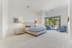 A bedroom with a large bed, two bedside tables, a window, and a view of the outdoors. - Lakeside luxury home w/ private pool & spa, fireplace & outdoor kitchen-dog ok (La Quinta)
