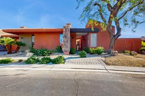 A modern house with a stone pillar, a paved driveway, and a well-maintained garden. - Lakeside luxury home w/ private pool & spa, fireplace & outdoor kitchen-dog ok (La Quinta)