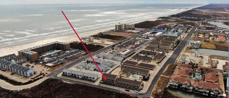 Vista aérea de una zona costera con un gran complejo hotelero, una playa y un puerto deportivo.