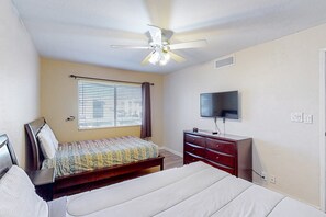 A bedroom with a bed, a dresser, a TV, and a ceiling fan. - Sun-filled condo with a patio, central AC, pool & grill access - great location (Scottsdale)