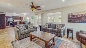 A spacious living area with two sofas, a coffee table, and a ceiling fan. - Scottsdale Style Meets Family-Friendly Fun! Spacious home with a yard and pool. (Scottsdale)
