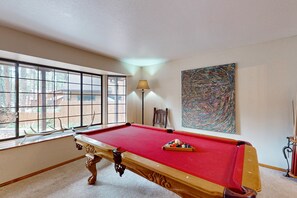 A pool table in a room with large windows, a lamp, and a painting on the wall. - Lavish retreat with game room, tranquil porch & scenic yard-near skiing & dining (Flagstaff)