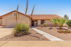 A single-story house with a garage, a front door, and a small patio area with plants. - Dog-friendly home with private pool, great backyard, and free WiFi (Mesa)