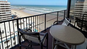 Uma varanda com vista para a praia e o oceano.