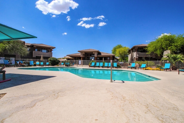 Ein Poolbereich mit Liegestühlen und einem Gebäude mit einem Ziegeldach.