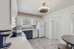 A modern kitchen with white cabinets, a built-in oven, and a window with a view. - Stylish Sam Hughes Escape With Private Yard, Dogs OK & Free WiFi (Tucson)
