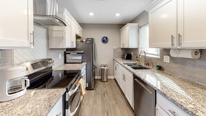 A modern kitchen with white cabinets, granite countertops, a stainless steel refrigerator, a built-in oven, and a microwave. - Snowbird-friendly home with central AC, washer/dryer & free WiFi - near golf (Phoenix)