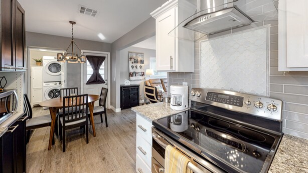A modern kitchen with a built-in oven, a coffee maker, and a dining area with a table and chairs. - Snowbird-friendly home with central AC, washer/dryer & free WiFi - near golf (Phoenix)