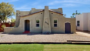A single-story building with a unique architectural design, featuring a central arched doorway and multiple windows.