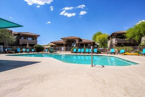 A swimming pool area with lounge chairs and a building with a tiled roof. - Comfy, dog-friendly condo with mountain views, pool, hot tub & gym (Oro Valley)