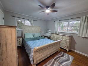 A bedroom with a wooden bed, a dresser, a nightstand, a ceiling fan, and a window with curtains. - Great location: UT, Windorck, national lab, melton lake park (Oak Ridge)
