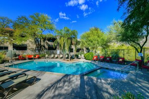 A pool area with lounge chairs, a small pool, and surrounding greenery. - Beautifully remodeled dog-friendly Casita with shared heated pool & hot tub (Tucson)